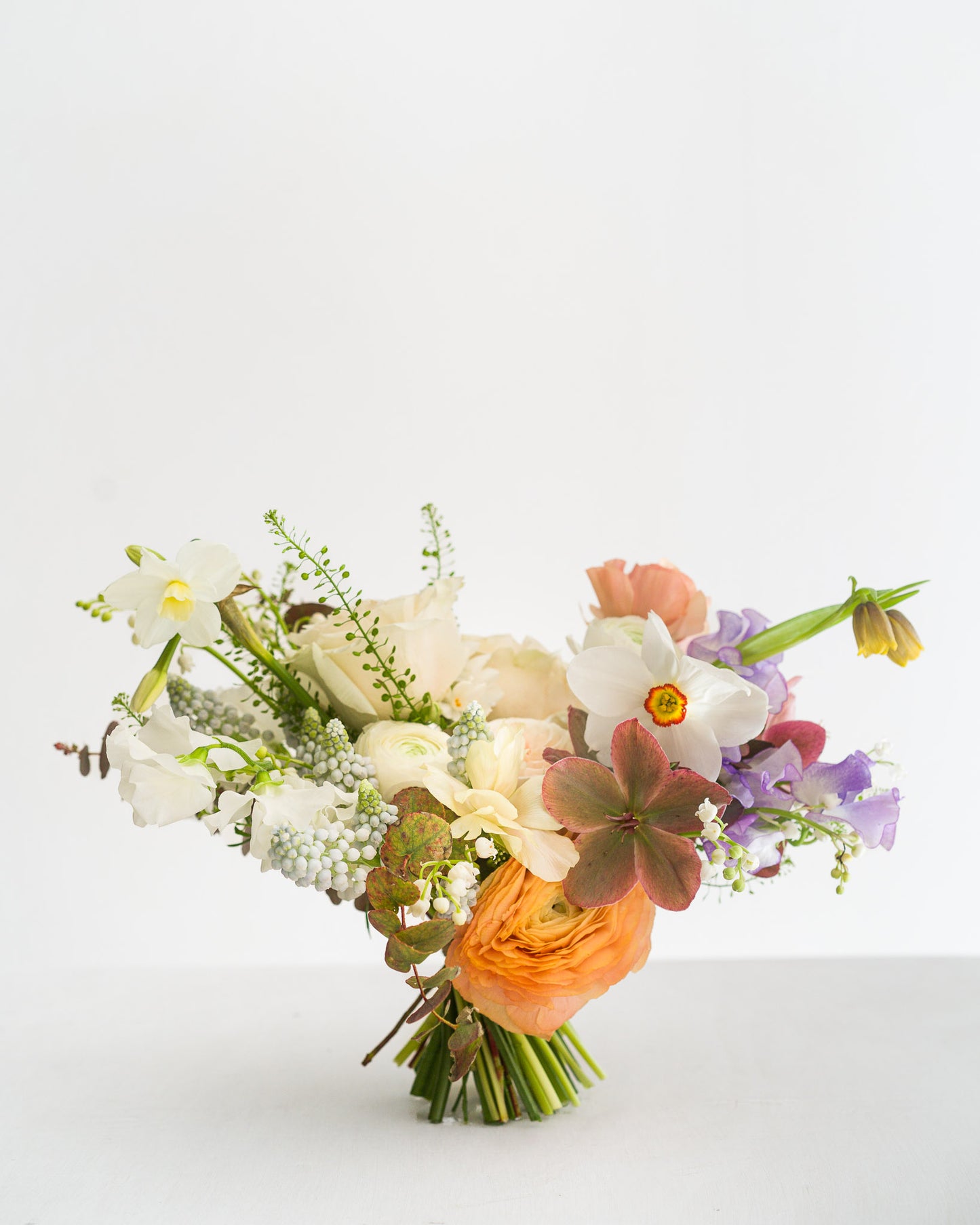 Beautiful spring Bridesmaid Bouquet featuring delicate spring flowers including narcissus flowers, sweetpeas, fritillaria, ranunculus and hellebore from Aspen Florals Wedding Collection Edinburgh Florist