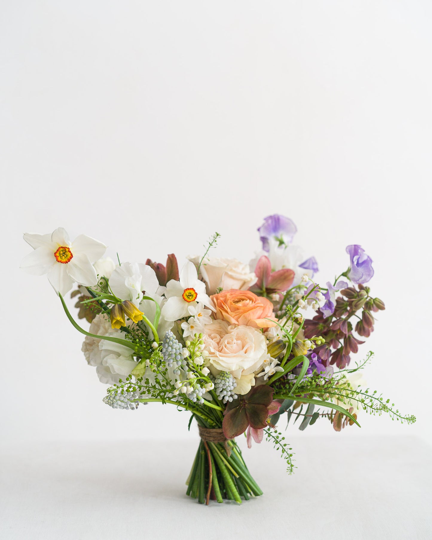 Beautiful spring Bridesmaid Bouquet featuring delicate spring flowers including narcissus flowers, sweetpeas, fritillaria, ranunculus and hellebore from Aspen Florals Wedding Collection Edinburgh Florist