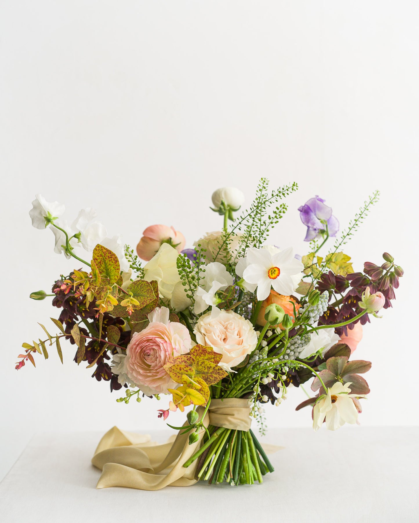 Beautiful spring Bridal Bouquet featuring delicate spring flowers including narcissus flowers, sweetpeas, fritillaria, ranunculus and hellebore from Aspen Florals Wedding Collection Edinburgh and Scotland wedding Florist